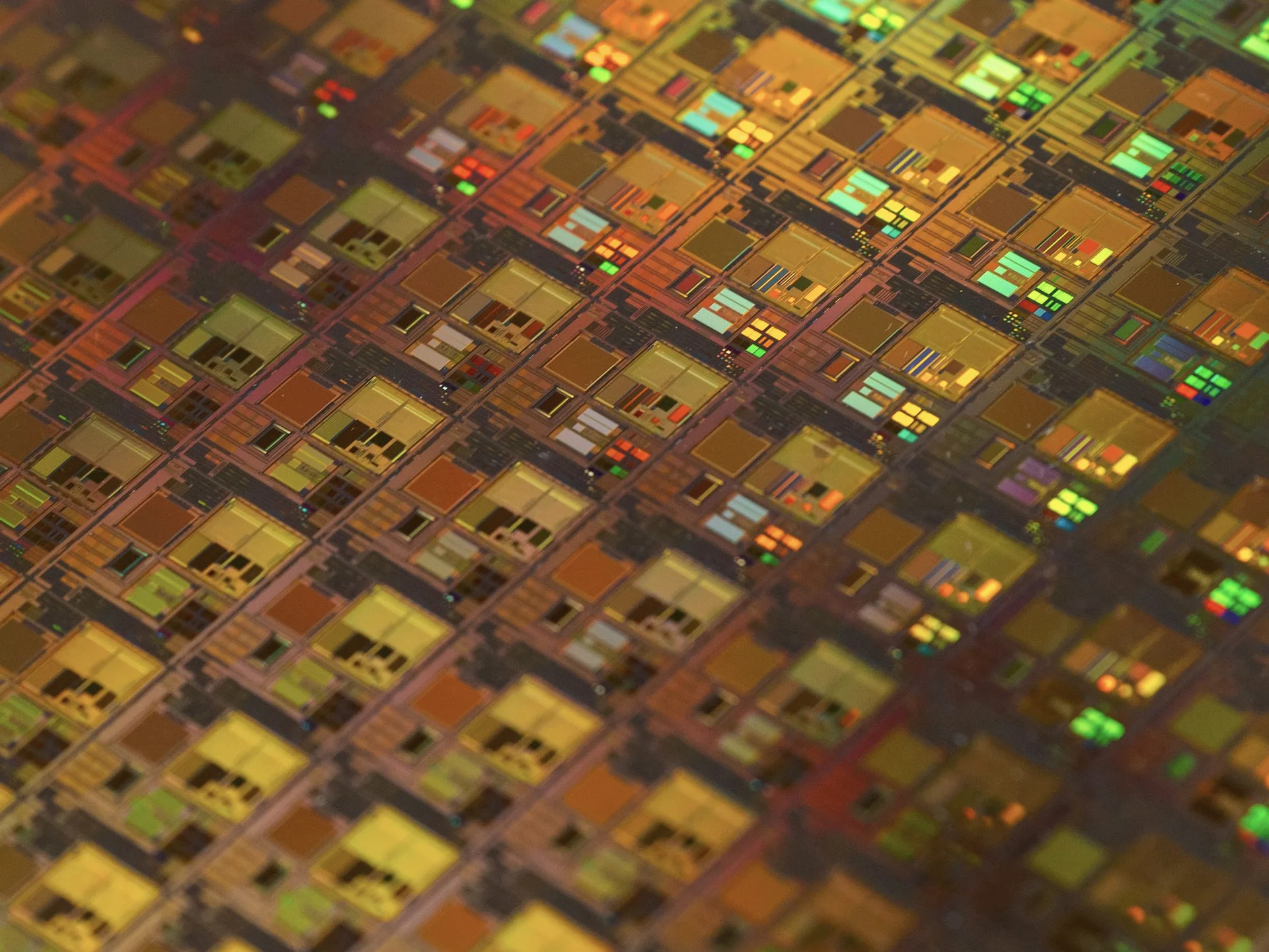 Industry context: Close-up of a patterned silicon wafer.
