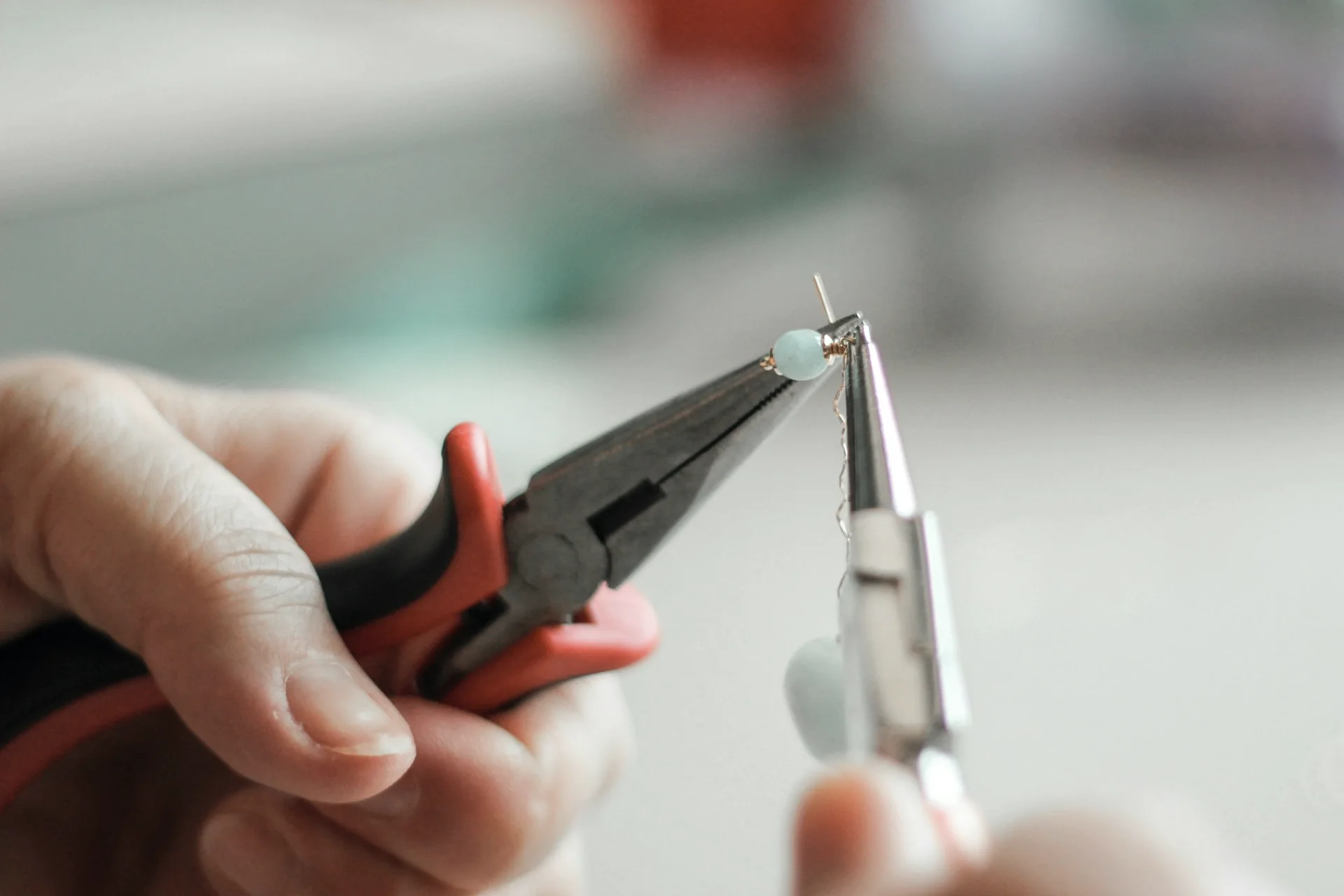 Industry context: Hands forming a jewellery component with pliers.