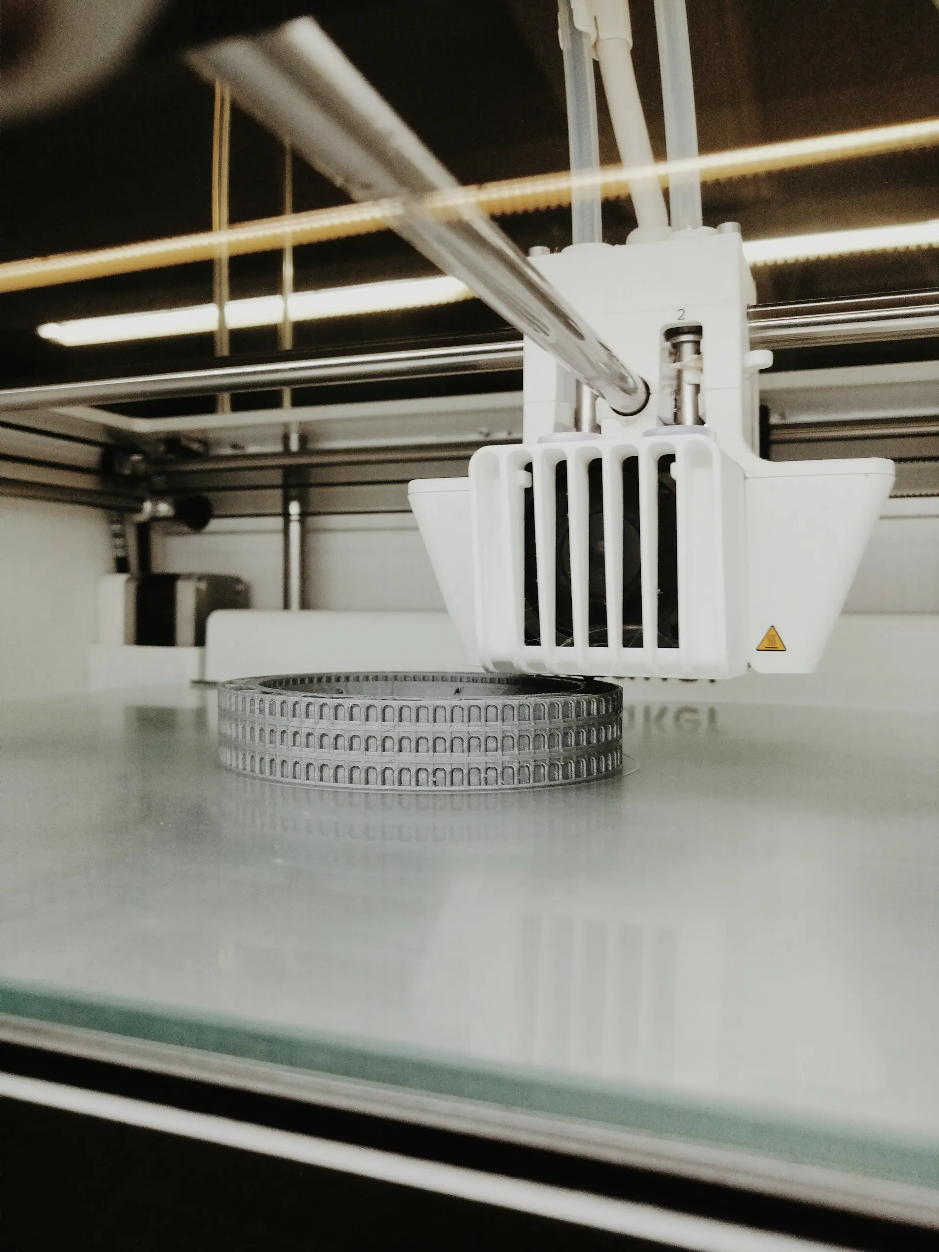 Industry context: Layered circular part on a 3D printer build plate.
