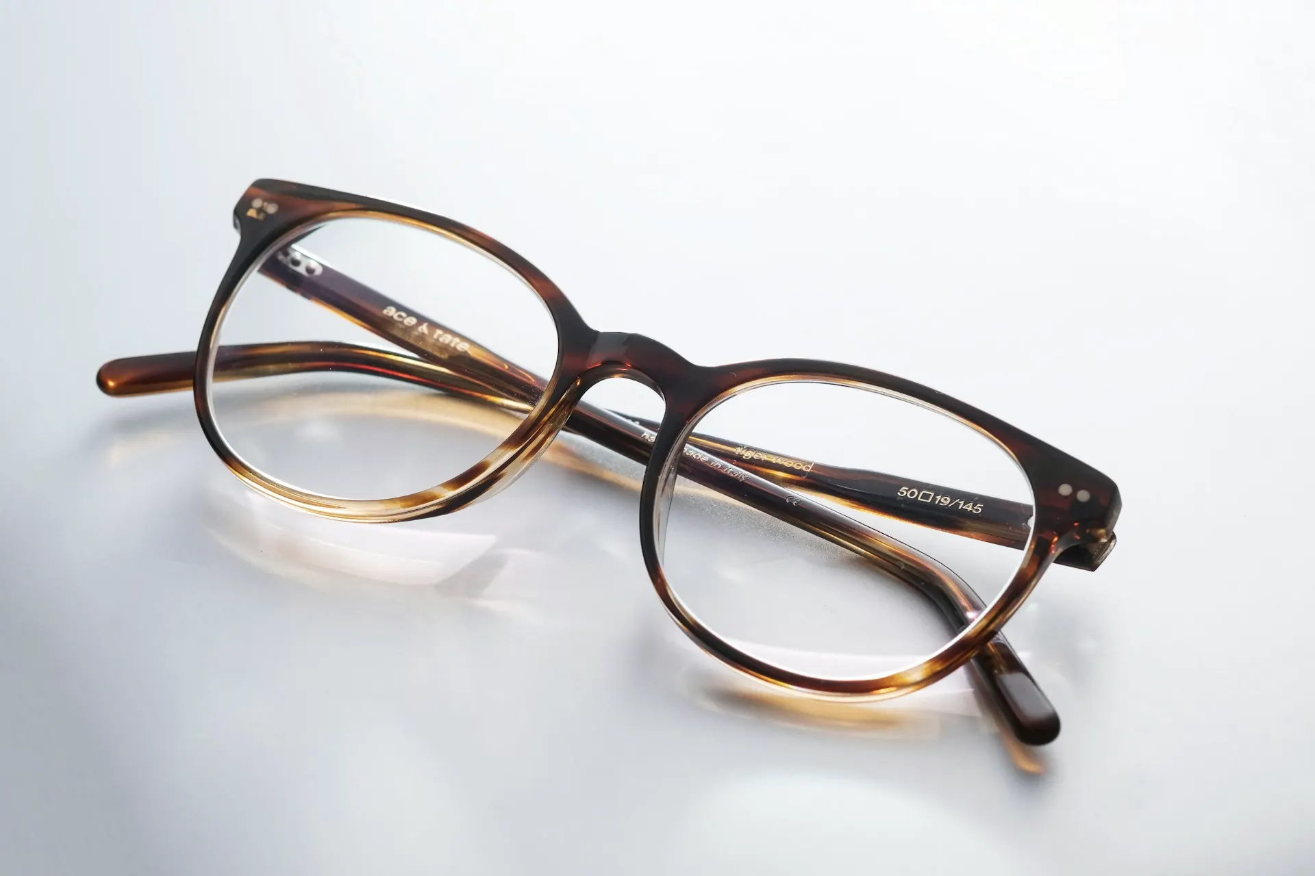 Industry context: Tortoiseshell eyeglasses on a pale surface.