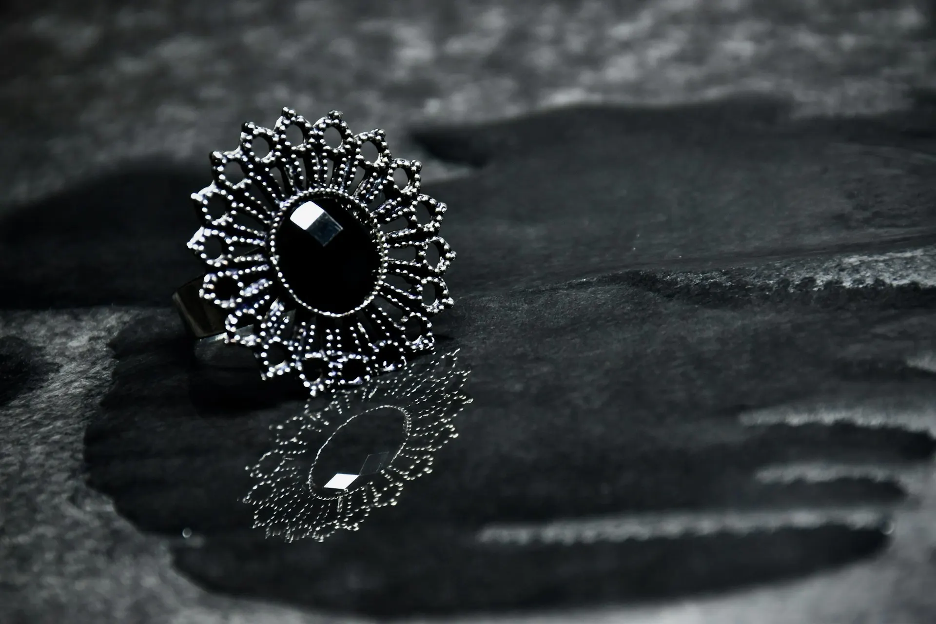 Industry context: Oxidised silver ring on a dark surface.