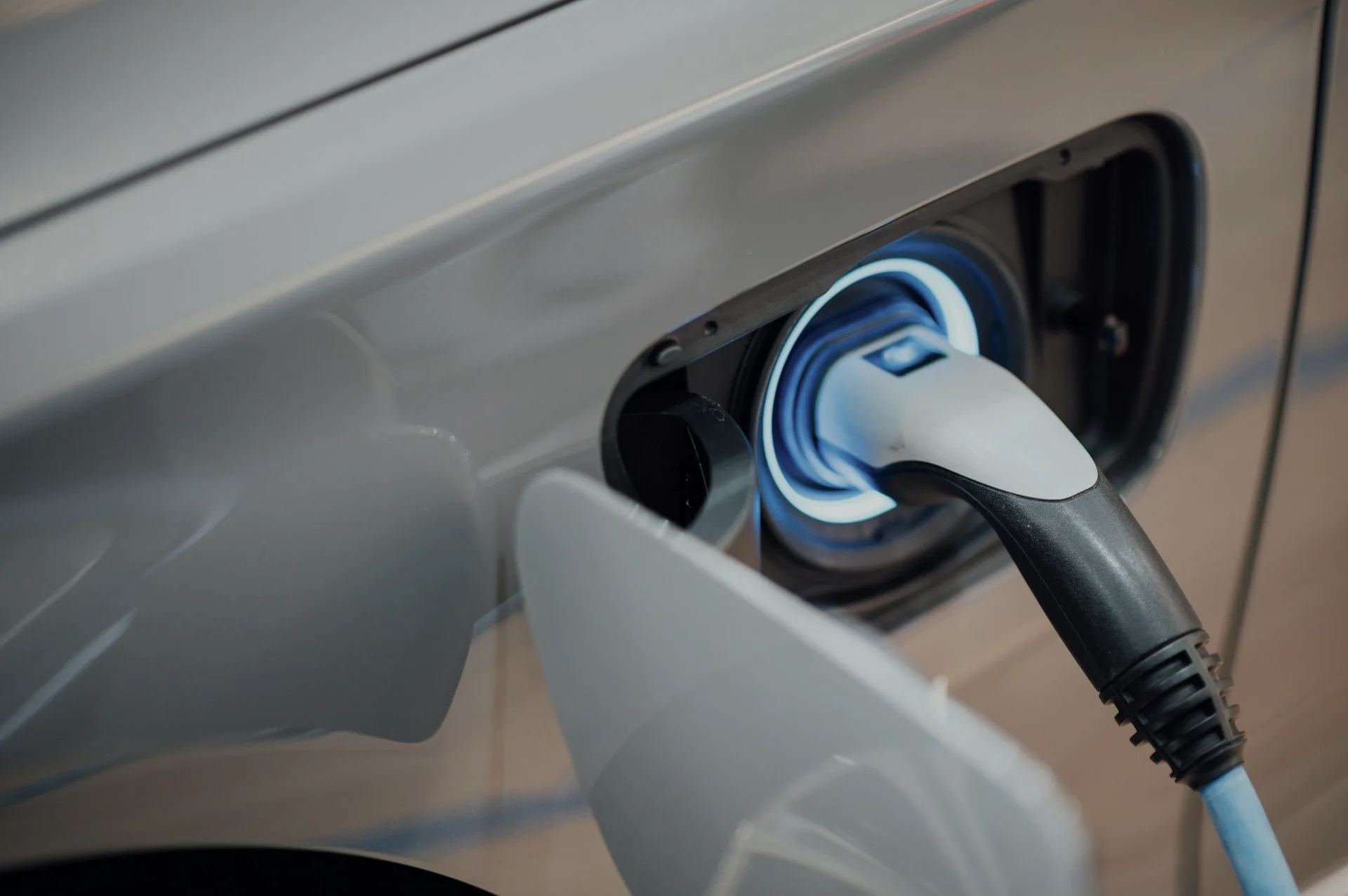 Industry context: Charging connector attached to an electric vehicle.